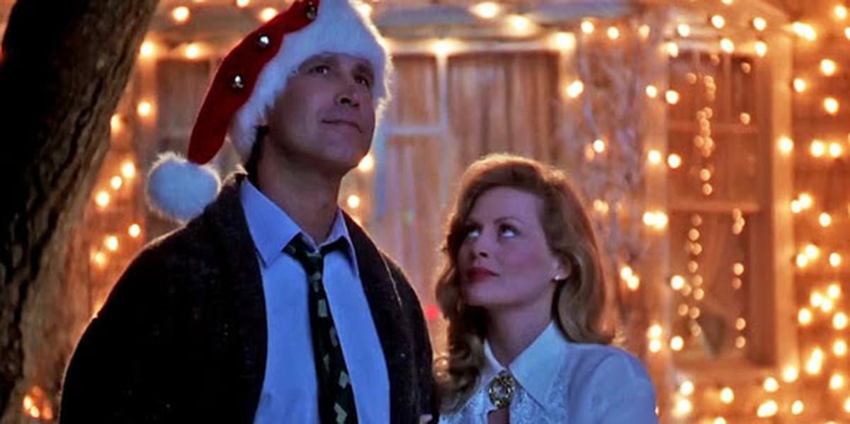 Clark and Ellen Griswold in front of their house, with Christmas lights on it, in Christmas Vacation