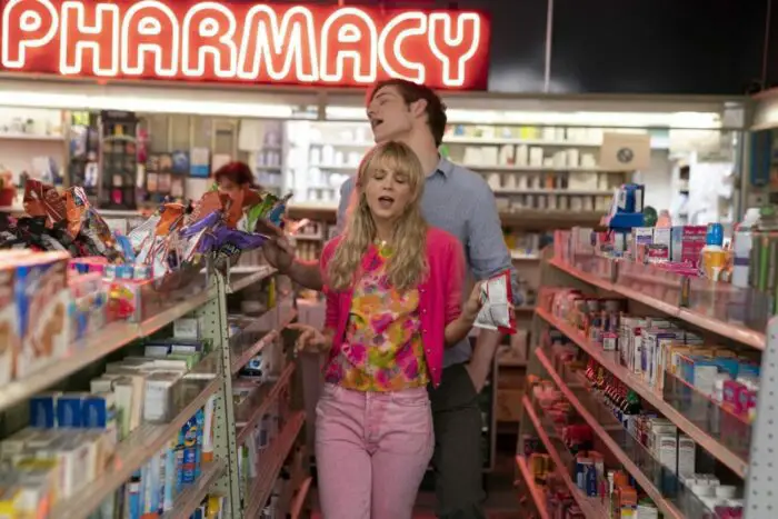 Cassie and Ryan dance and sing in a pharmacy aisle.