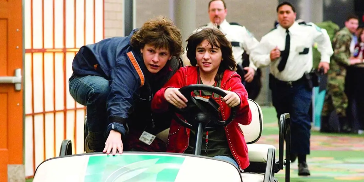 Spencer and Grace in Unaccompanied Minors driving airport car being chased by security guards