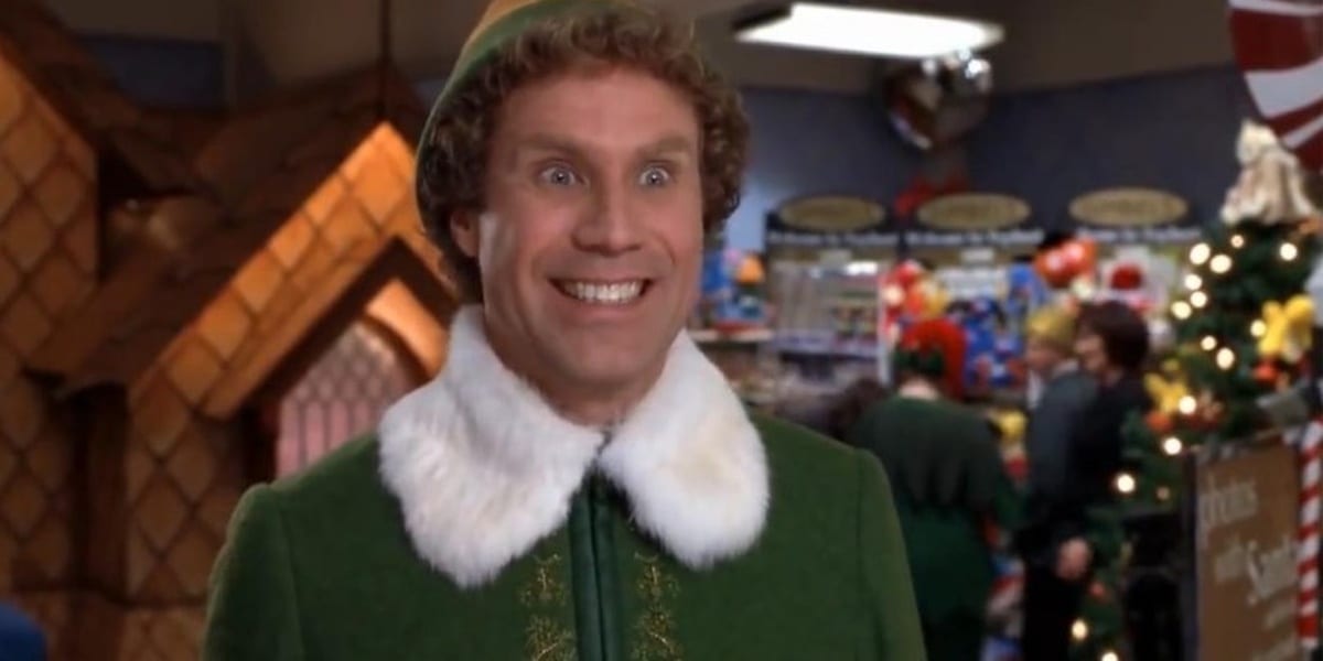Will Ferrell as Buddy in Elf, wearing his uniform and smiling