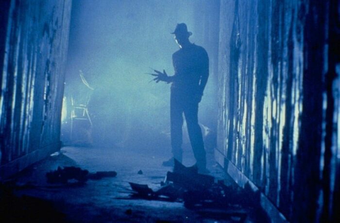 Freddy Krueger stands in a smoky hallway