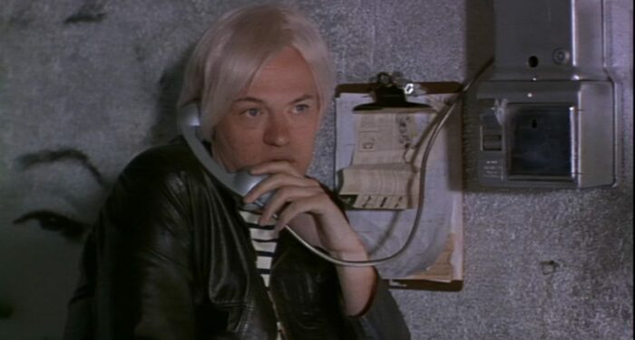 Andy Warhol (Jared Harris) uses a phone attached to the wall
