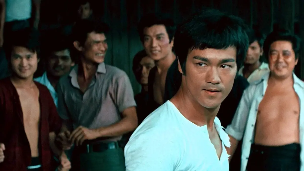 Bruce Lee stands in front of a group of men in The Big Boss