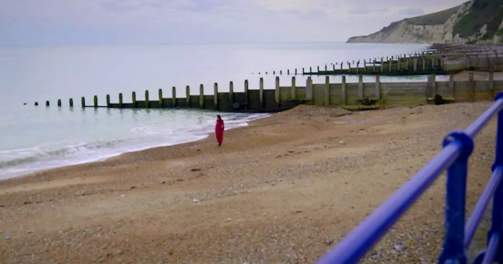 Filmmaker Nina Kojima stands alone on a beach in London