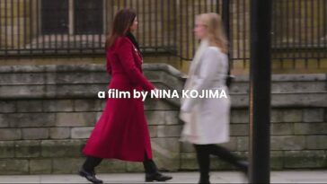 Two people walk towards each other on a sidewalk in a somewhat blurry still as "a film by Nina Kojima" appears on screen