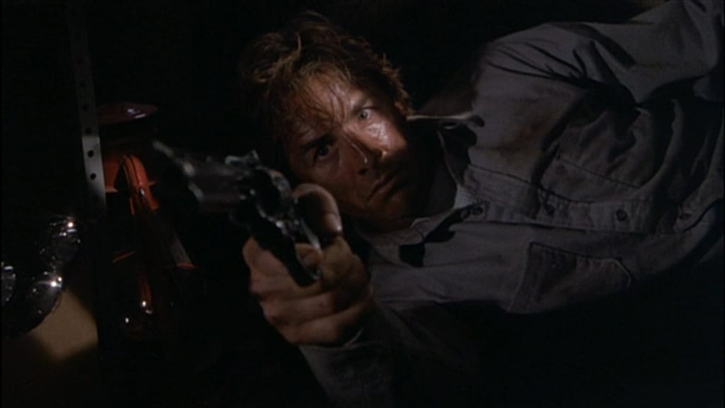 Jerry Beck on his side, holding his revolver out