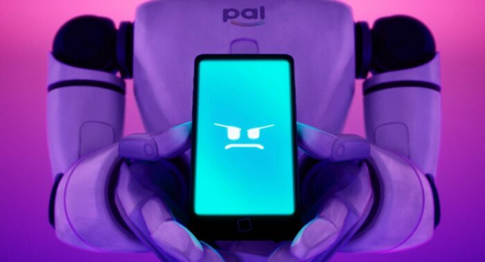 A PAL Max robot holds the PAL app in a phone.