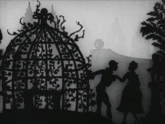 Still from Lotte Reiniger's Harlequin. The silhouette cutouts stand in front of an ornate dome in a garden.