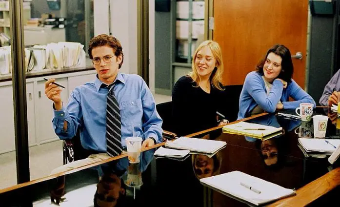 Stephen Glass sits at an office desk with Caitlyn Avery and Amy Brand behind him