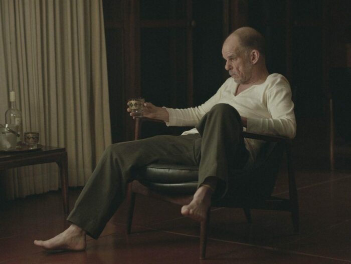 Denis Lavant sits pensively drinking whiskey in Rick Alverson's "The Mountain"