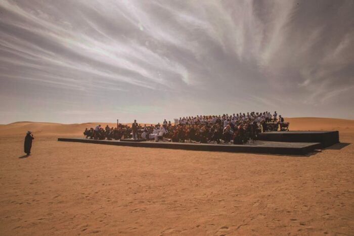Nayla Al Khaja directs a group of musicians in the Dubai desert