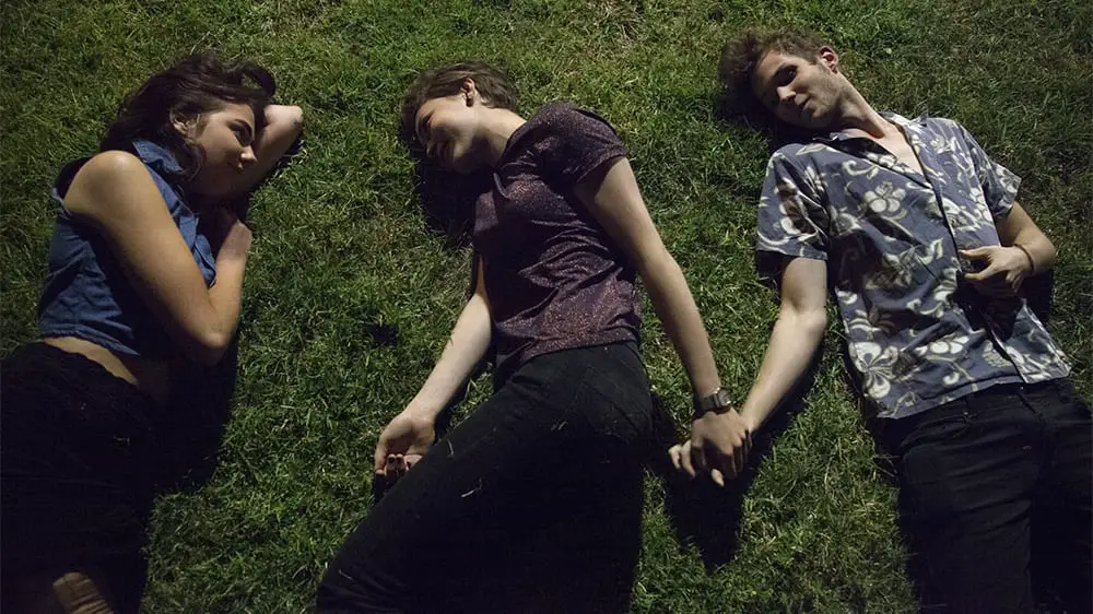 52 Tuesdays (2013) Billie (Tilda Cobham-Hervey) lies in the grass at night, gazing at Jasmine (Imogen Archer) while holding hands with Tom (Beau Travis Williams)