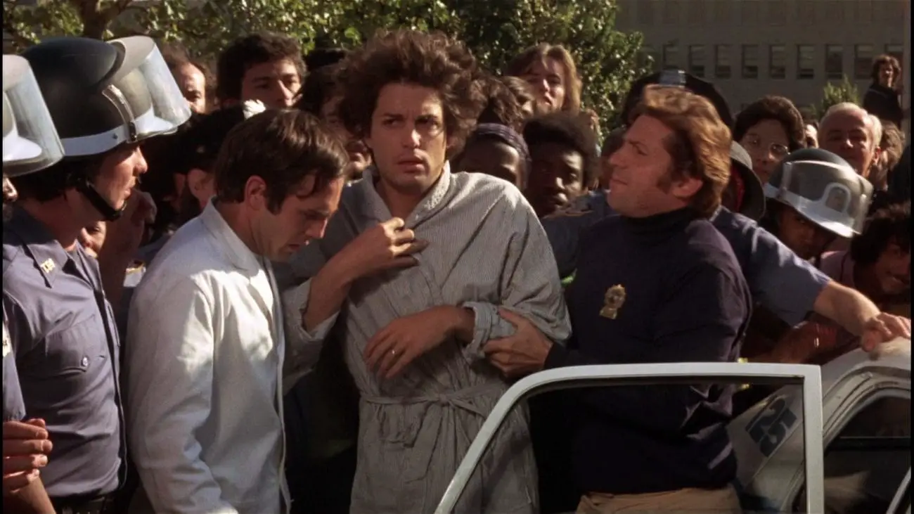 Dog Day Afternoon (1975) Chris Sarandon as Leon arrives at the negotiation in a bathrobe, surrounded by police and doctors