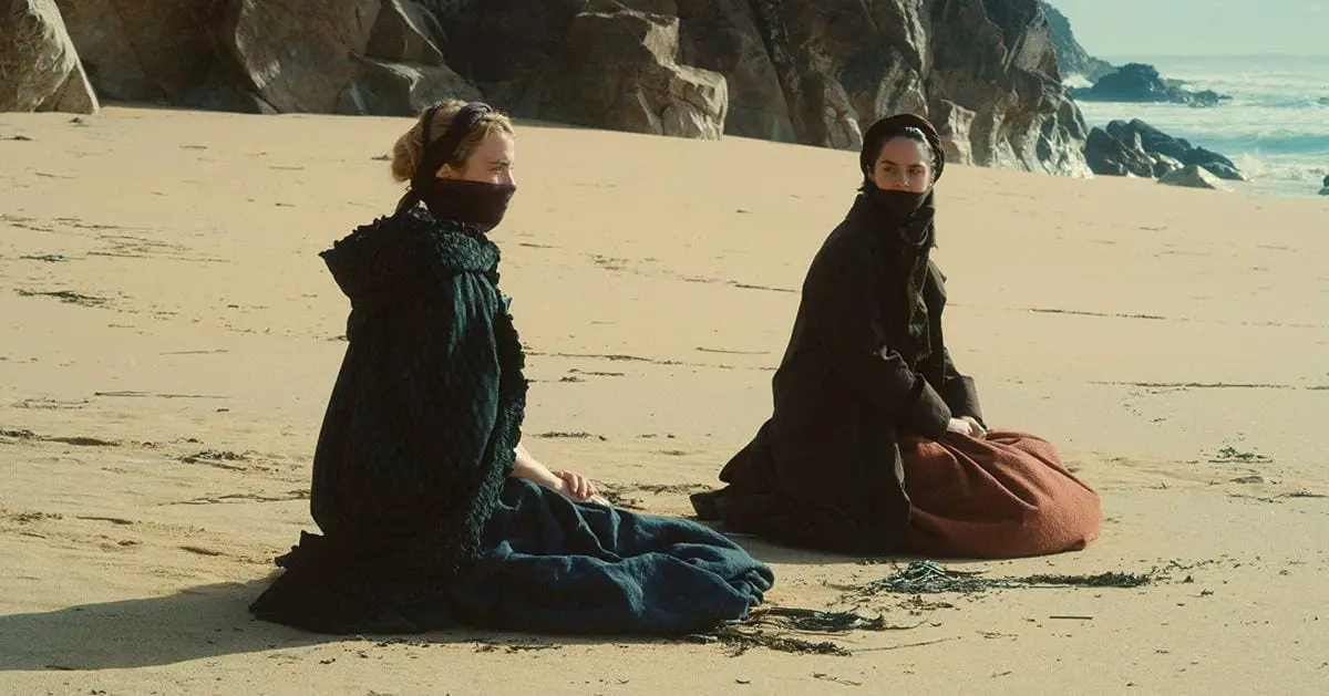 Marianne (Noemie Merlant) and Heloise (Adele Haenel) sit on the beach in Portrait of a Lady on Fire (2019)