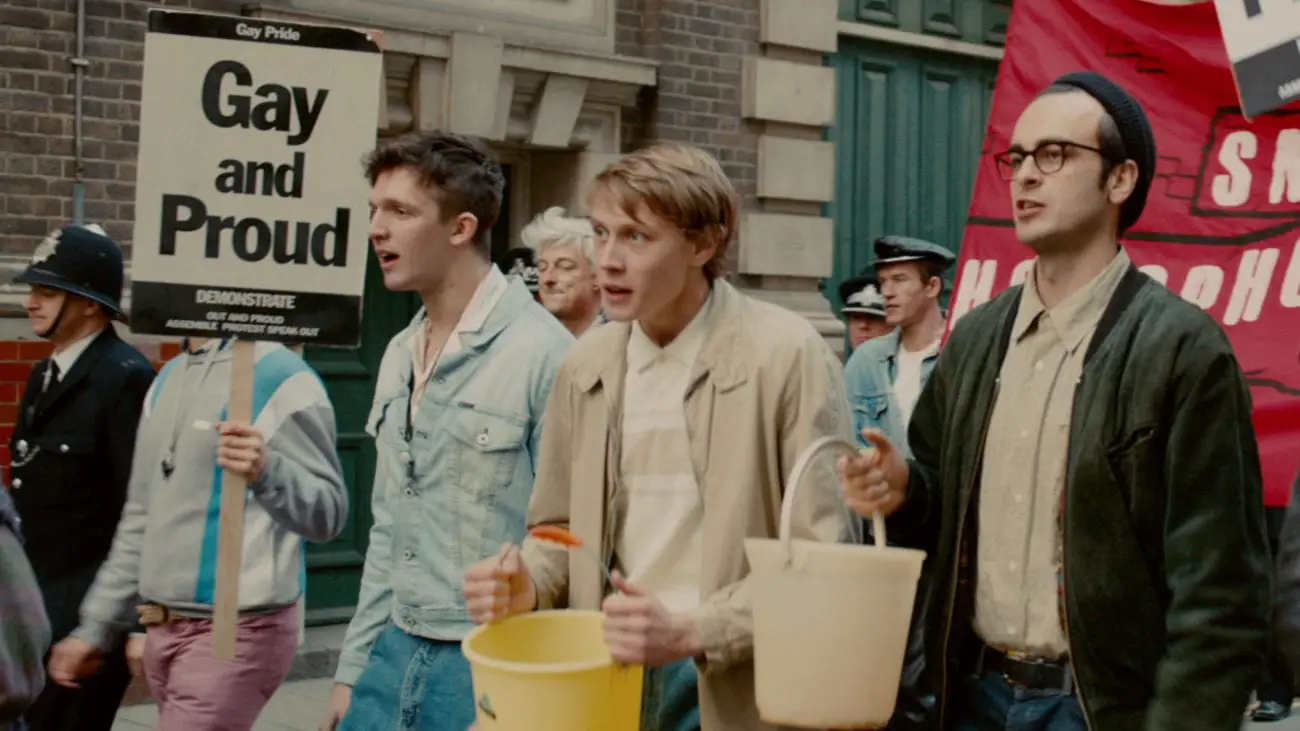 Pride (2014) cast marching in a pride parade (Geore MacKay and Joseph Gilgun)