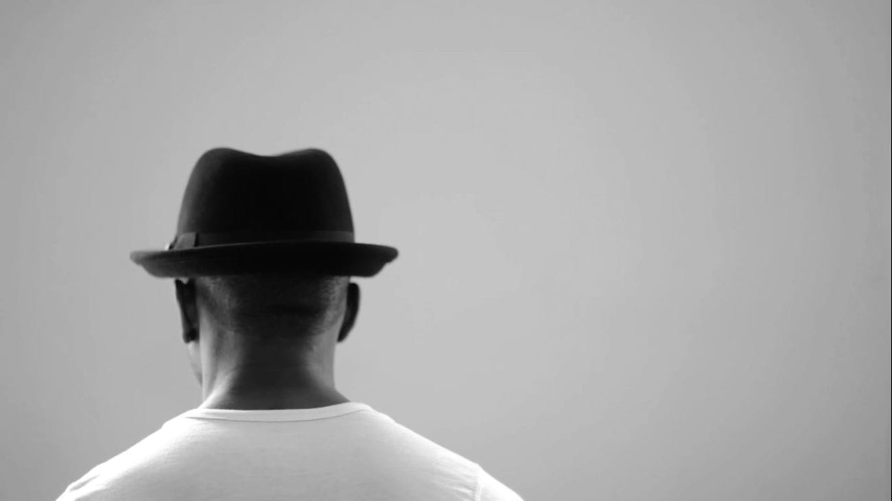 Still from #blackmendream, one of the new Criterion Channel Short Films. A man sits with his back to us. He is wearing a hat and a white t-shirt.