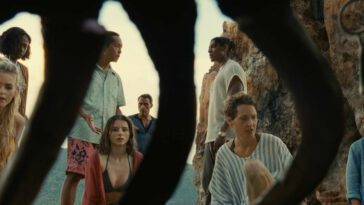 Prisca (Vicky Krieps), Maddox (Thomasin McKenzie), and others on the mysterious island stare in confusion as a dead body has fully decomposed within of few hours.