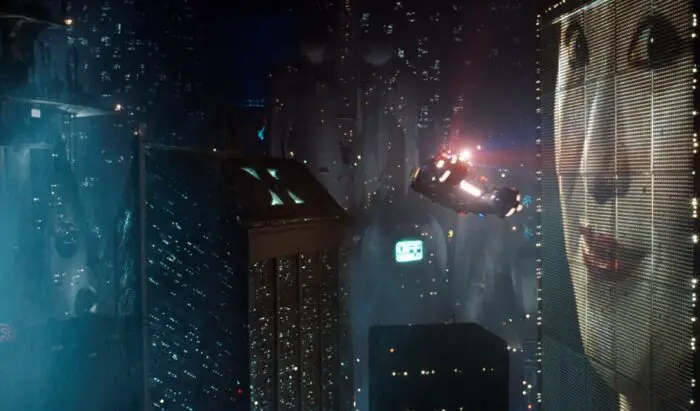 A flying car makes its way through elevated streets and billboards.