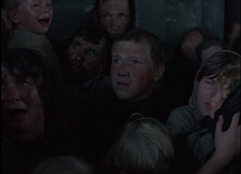 In this image from Come and See, Flyora is depicted in a crowd of Perekhody villagers trapped in a barn by Nazi Secret Service officers.