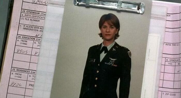 In this image from Courage Under Fire, Capt. Walden (Meg Ryan) is depicted in military dress in a dossier.