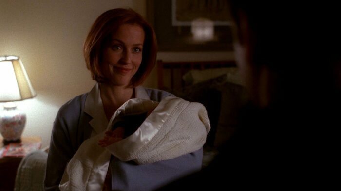 Scully smiles at Mulder while holding her newborn son (The X-Files S8E21)