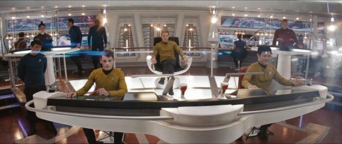 The bridge crew of the Enterprise prepare the embark from their stations.