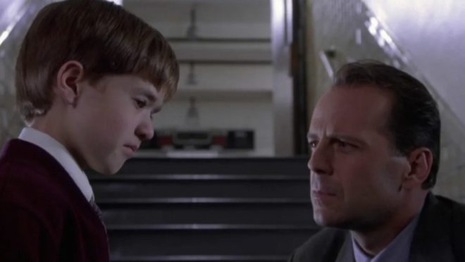 Malcolm (Bruce Willis) is comforting a terrified Cole (Haley Joel Osment) after Cole just saw the ghosts in his school hallway.