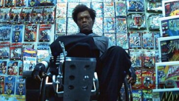 A wheel-chair bound Elijah Price (Samuel L. Jackson) sits in a comic book shop staring blankly.
