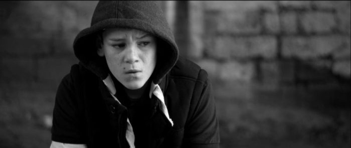 Still from What If. Joe looks emotional while wearing a hoodie.