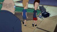 Beavis and Butt-Head walk down the stairs towards a broken TV as their principal looks on