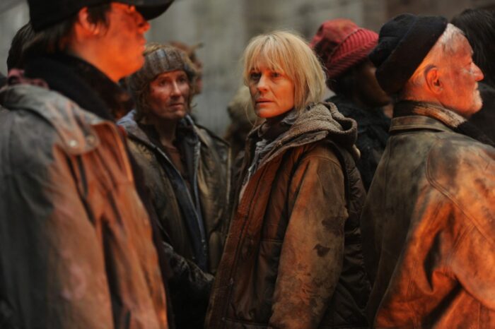 Robin Wright looks old and dissheveled, wearing a hooded jacket in a crowd
