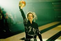 McCracken holds the bowling ball into the air in celebration.