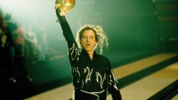 McCracken holds the bowling ball into the air in celebration.