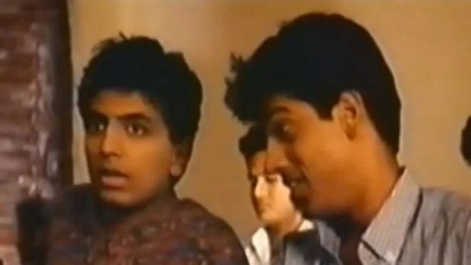 Dev (M. Night Shyamalan) and Sanjay (Mike Muthu) talk about a girl who just walked into their classroom at their college university in India.