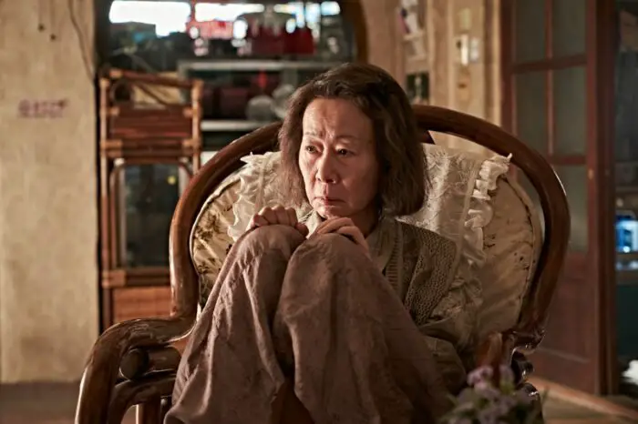 Alzheimer's sufferer Soon-ja (Youn Yuh-jung), mother to Joong-man, sits huddled in front of the TV