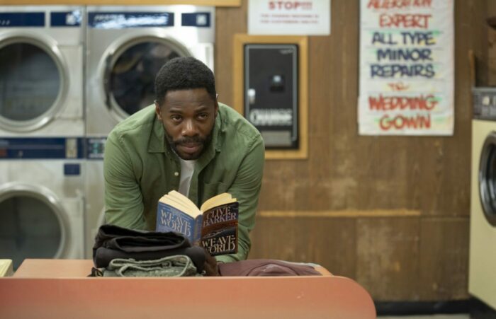 William reads a book in a laundromat.