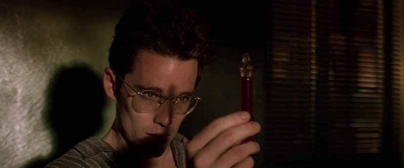 In this image from Gattaca the character Vincent Freeman (played by Ethan Hawke) is depicted in shadowy close-up, holding a vial of blood for inspection.