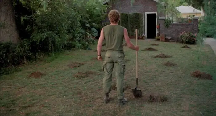 Roger looks over the backyard with fresh holes and and holding a shovel.
