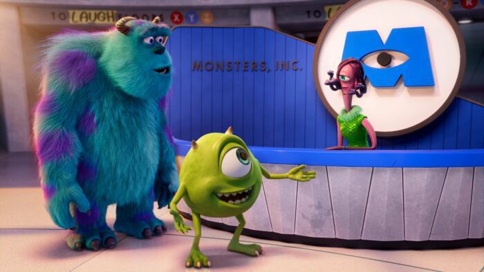 Sulley and Mike, talk with Celia at the front desk of Monsters, Inc.
