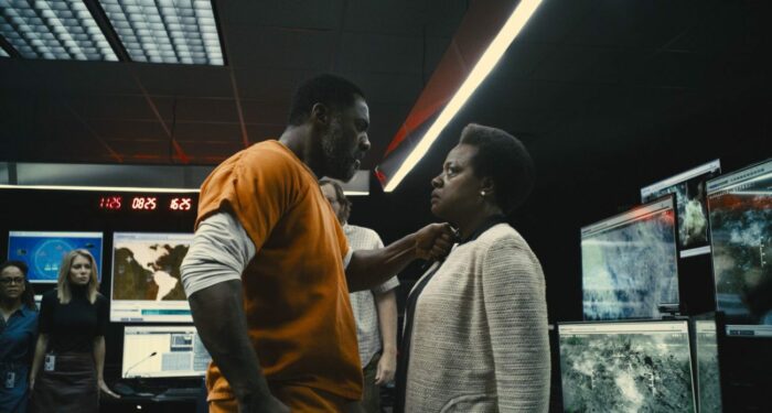 Bloodsport stands close to hold a blade to Amanda Waller's throat.
