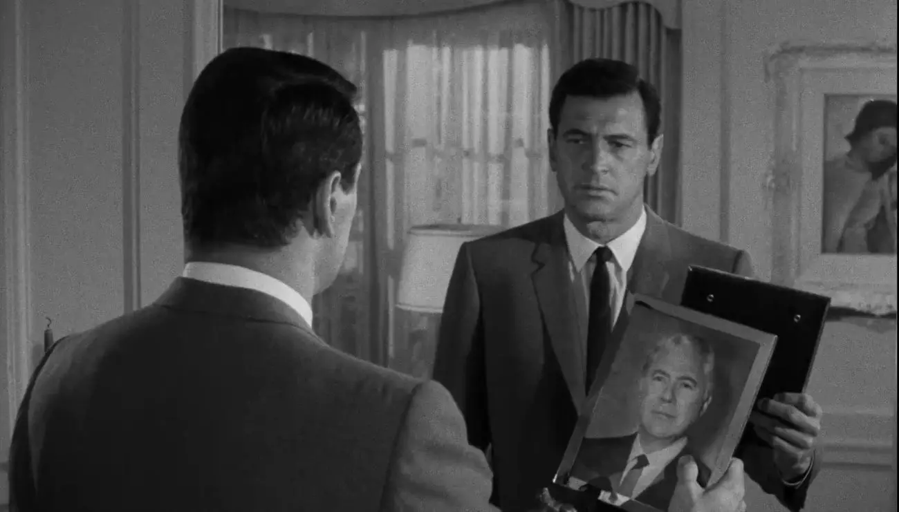 In this image from Seconds, Antiochus "Tony" Wilson (Rock Hudson) is depicted gazing into a mirror image of himself and holding a portrait of his former self Arthur Hamilton (John Randolph).