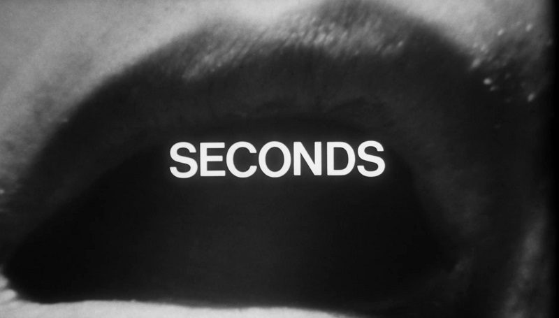The title card for Seconds depicts a stretched, warped image of an open human mouth with the title "Seconds" superimposed in upper case. 