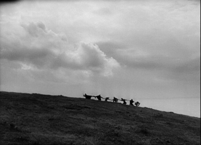 In this image from The Seventh Seal, Death is depicted leading his six victims in a dance along the hillside.