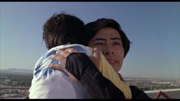 Cho holds Kane in his arms.