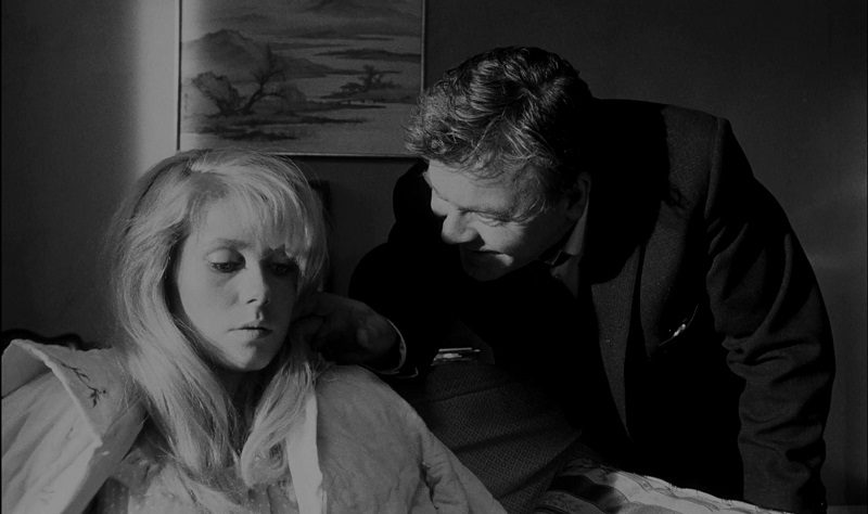 In this image from Repulsion, Carol is depicted looking downward in discomfort as her landlord (Patrick Wymark) leeringly propositions her from behind.