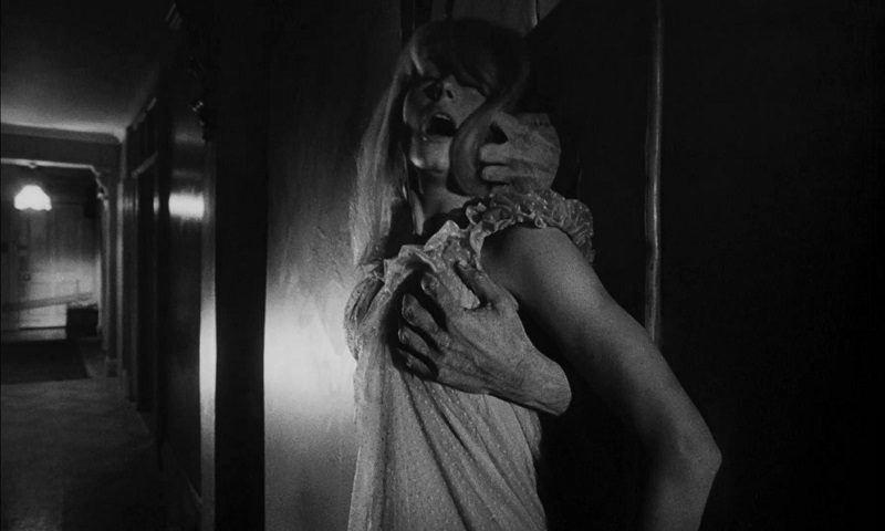 In this image from Repulsion Carol is grabbed from behind by hands that emanate from the apartment walls.