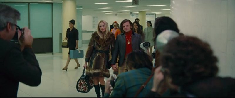 In this image from Once Upon a Time ... in Hollywood, the character of Roman Polanski (played by Rafal Zawierucha) is depicted arriving in an airport alongside Margot Robbie's character Sharon Tate.