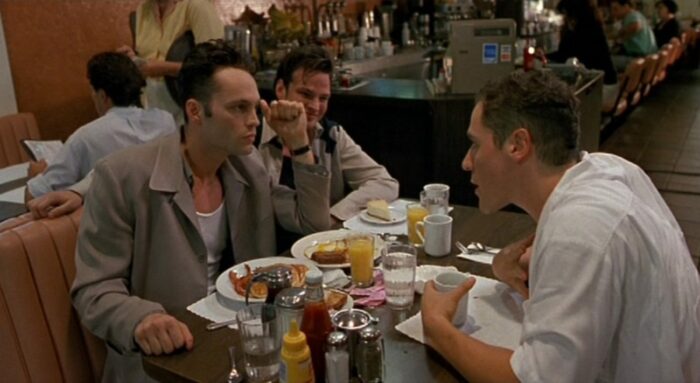 Three friends share a conversation at a diner.