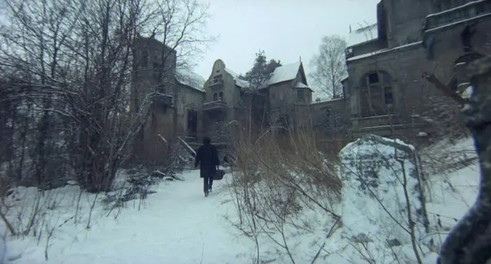A man walks through snow, carrying a briefcase, in The Hourglass Sanatorium
