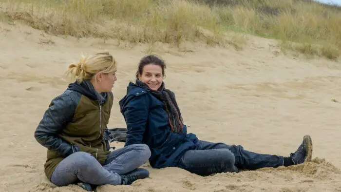 Chrystele (Helene Lambert) and Marianne (Juliette Binoche) laughing on the beach